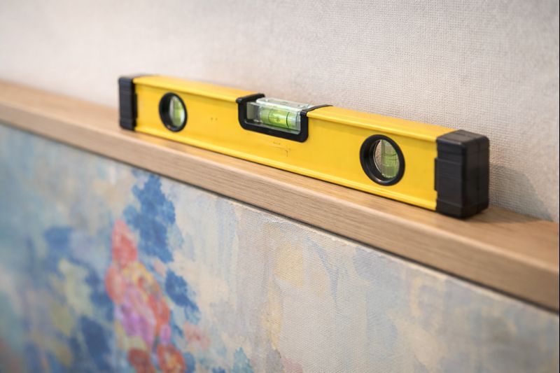 Level from Proper Placement Studio team across top of recently installed painting